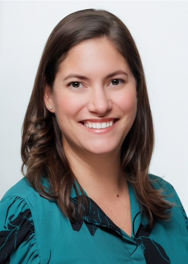Katherine Gehrmann, a woman with shoulder-length brown hair, wearing a teal blouse, smiles at the camera against a plain white background.